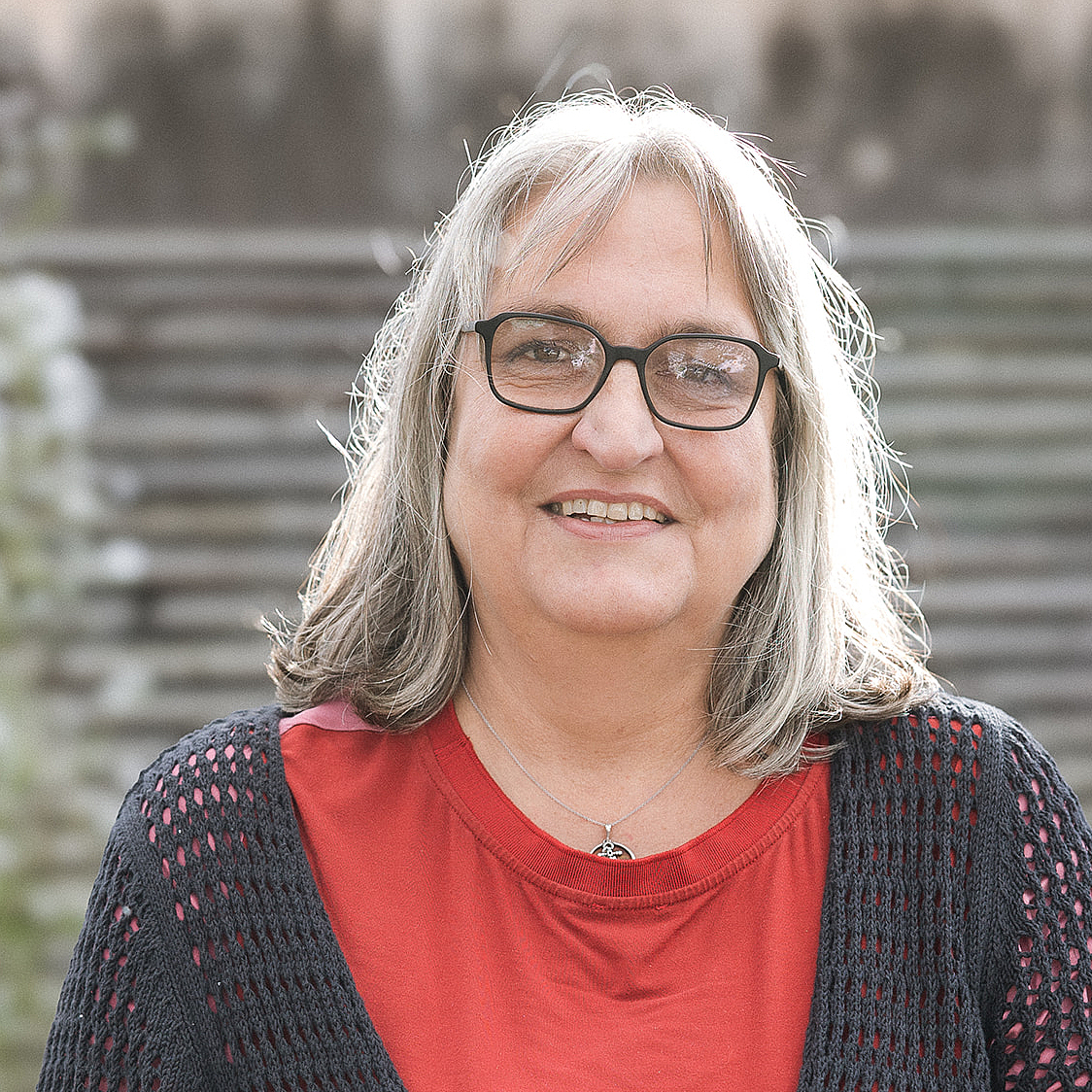 Portrait von Claudia Böker, der stellvertretenden Schulleitung der Berufsfachschule Agatharied, mit schulterlangen, grauen Haaren und Brille, die ein rotes T-Shirt trägt.Portrait von Claudia Böker, der stellvertretenden Schulleitung der Berufsfachschule Agatharied, mit schulterlangen, grauen Haaren und Brille, die ein rotes T-Shirt trägt.