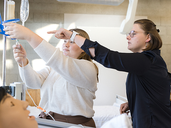 Realitätsnahe Übungen in der Pflegeausbildung unter Anleitung Eine Lehrerin der Berufsfachschule Agatharied erklärt einer Auszubildenden an einer lebensechten Pflegepuppe, wie eine Infusion korrekt vorbereitet und angelegt wird.